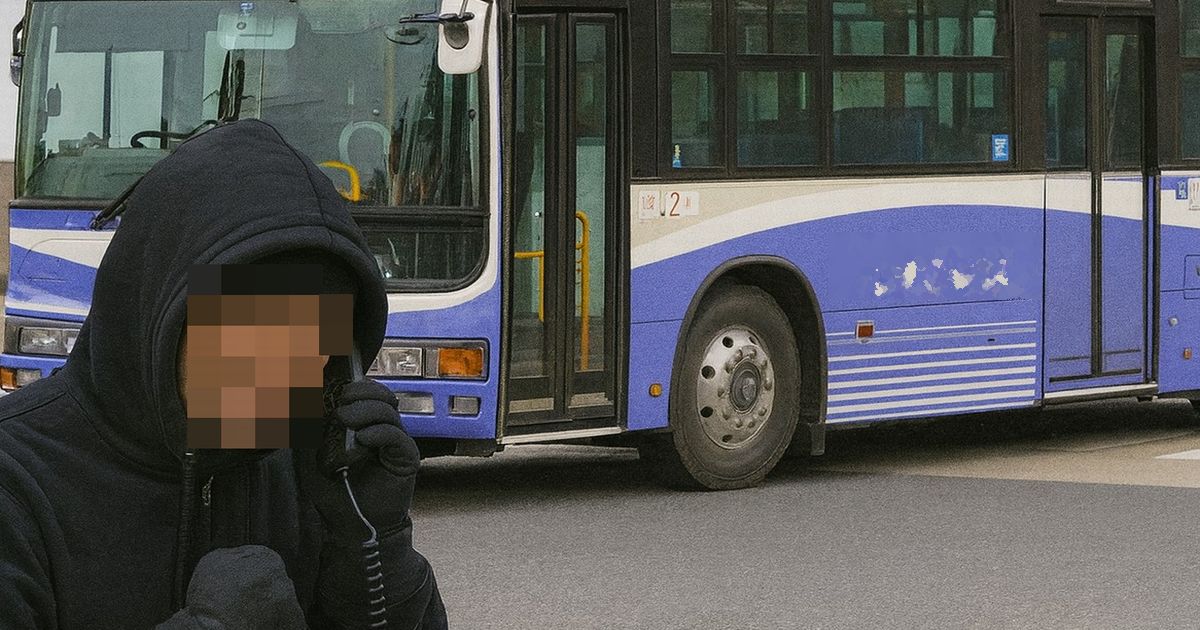 フードを被った人物が電話をする詐欺の現場イメージ。背景には青と白の路線バスが停車している。