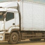 埃をかぶった大型トラックがアニメ風に描かれたイラスト