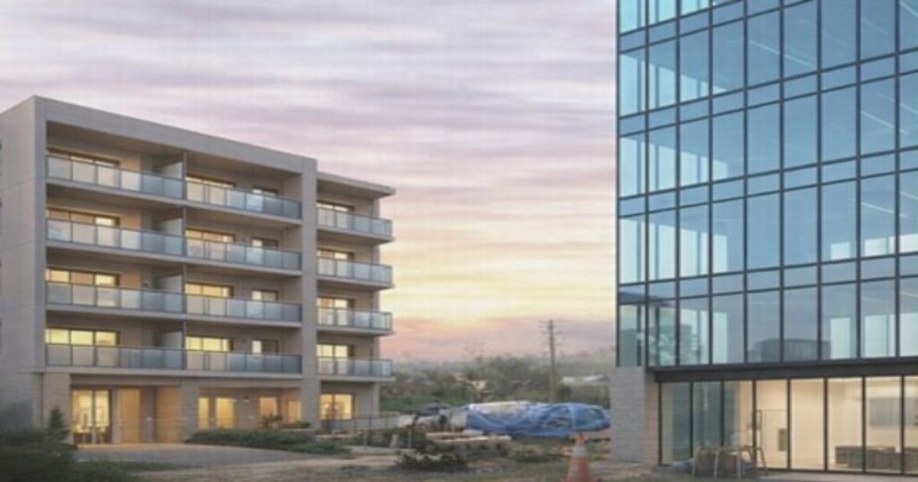 左に集合住宅マンション、右にガラス張りのオフィスビルが並ぶ都市風景